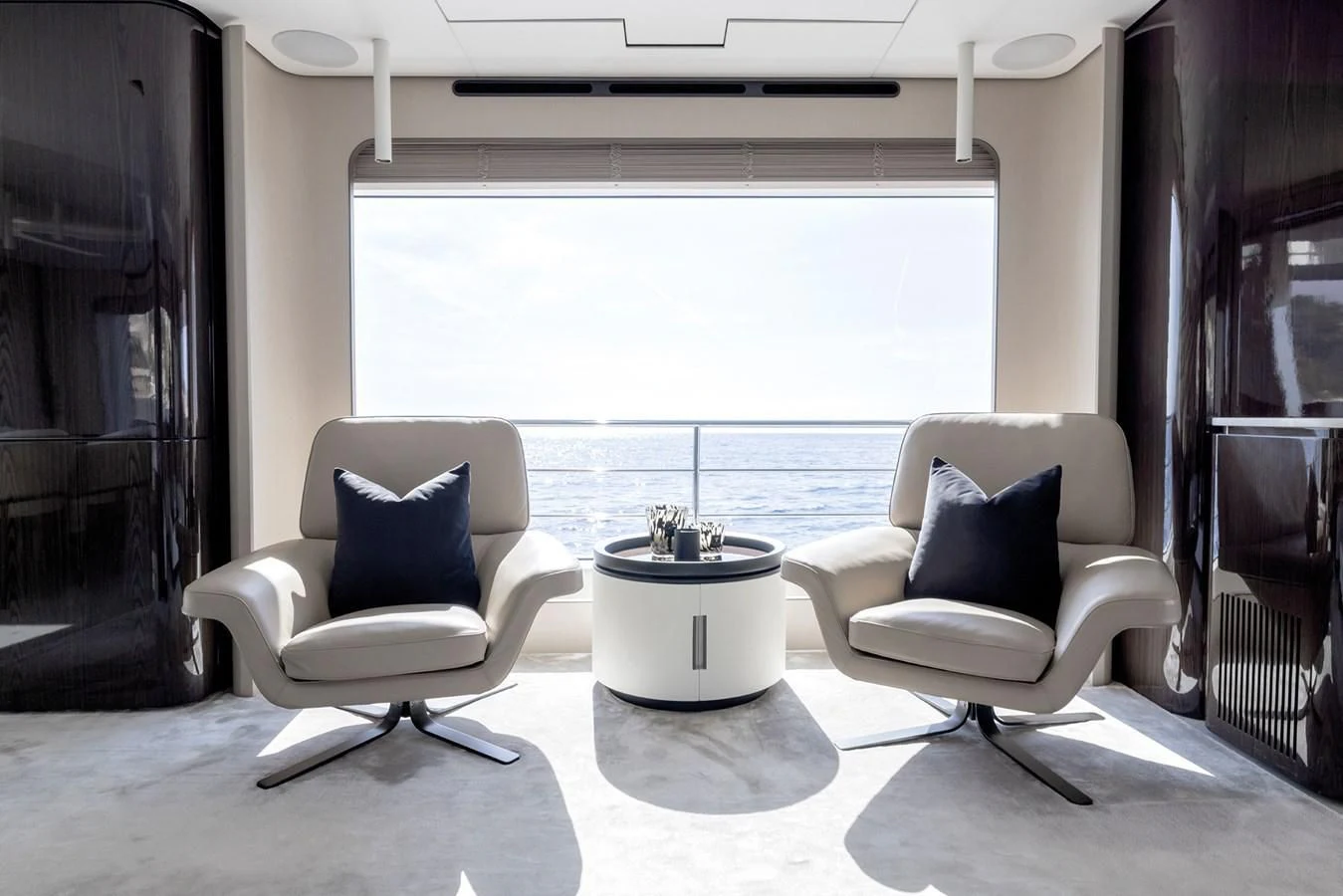 a couple of white chairs in a room with a large window aboard AZIMUT GRANDE 32M Yacht for Sale