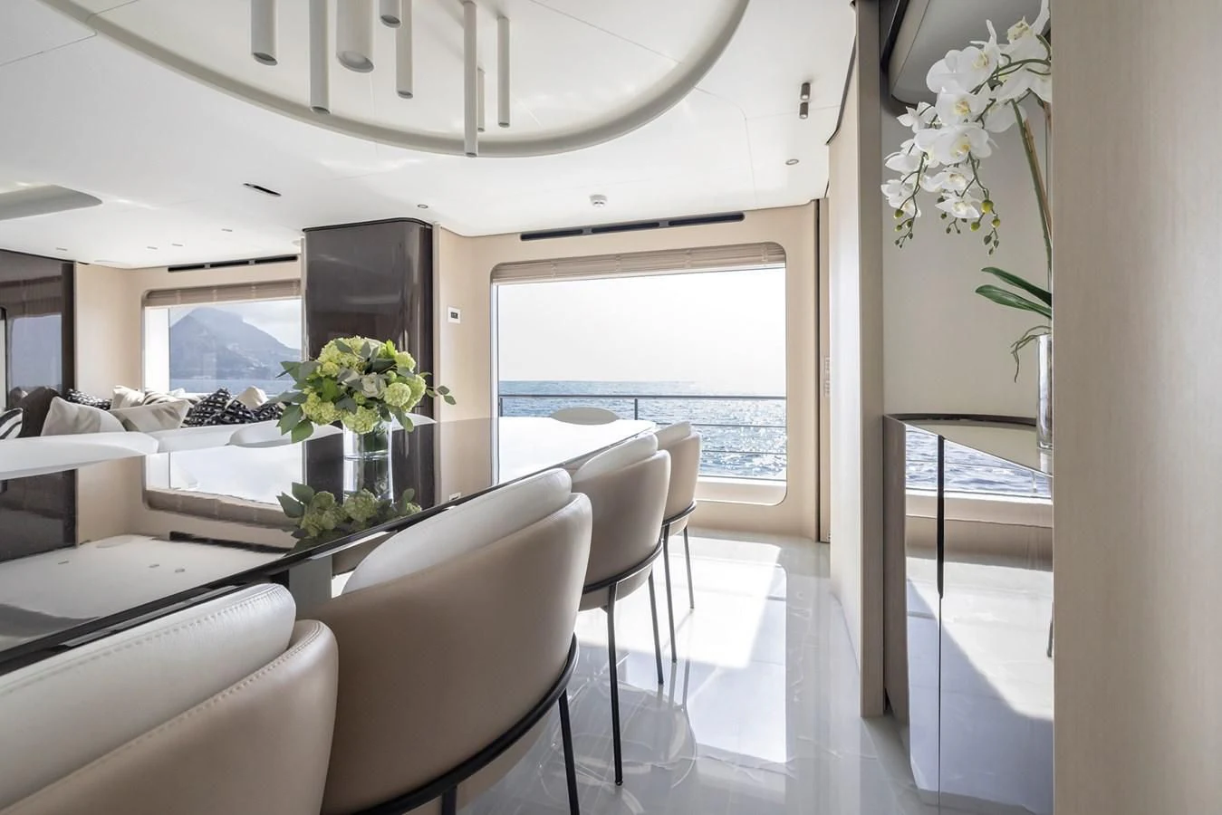 a room with white chairs and a table with flowers on it aboard AZIMUT GRANDE 32M Yacht for Sale