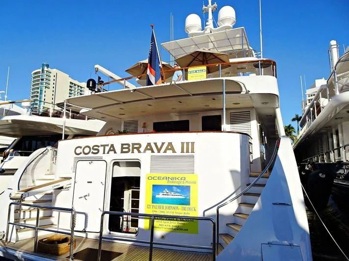 a large white boat with flags on it aboard COSTA BRAVA III Yacht for Sale