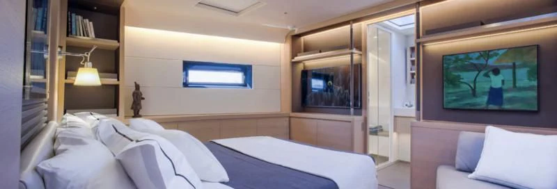 a room with a bed and a tv on the wall aboard AMMONITE Yacht for Sale