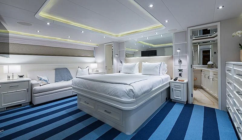 a room with a bed and a blue rug aboard LIBERTAS Yacht for Sale