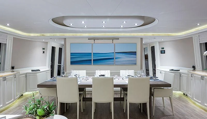 a large room with a table and chairs aboard LIBERTAS Yacht for Sale