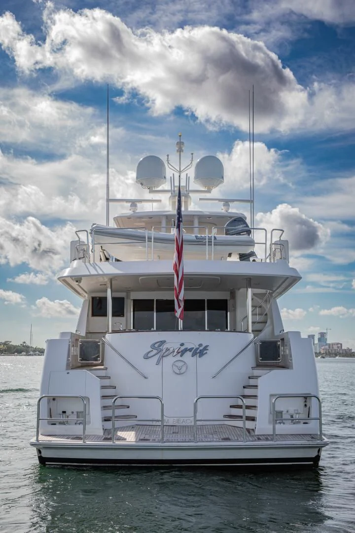 a white boat with a flag on it aboard LIBERTAS Yacht for Sale