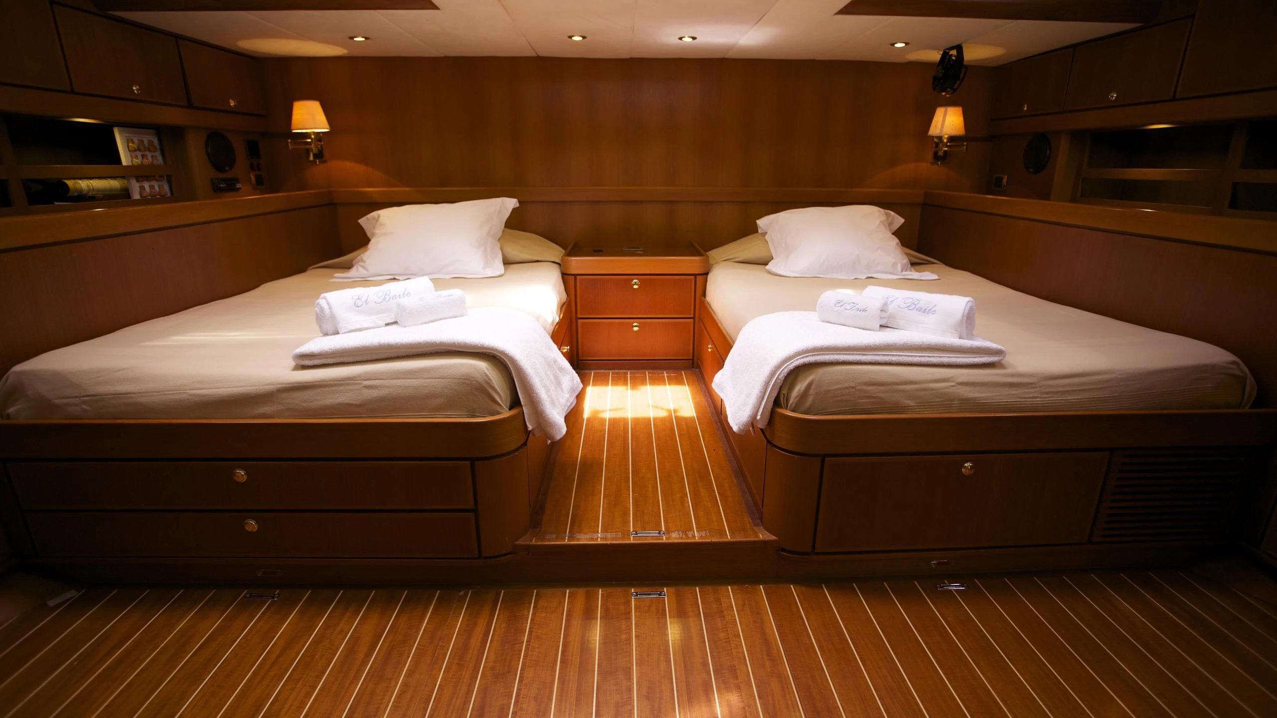 a room with beds and a wood floor aboard EL BAILE Yacht for Sale