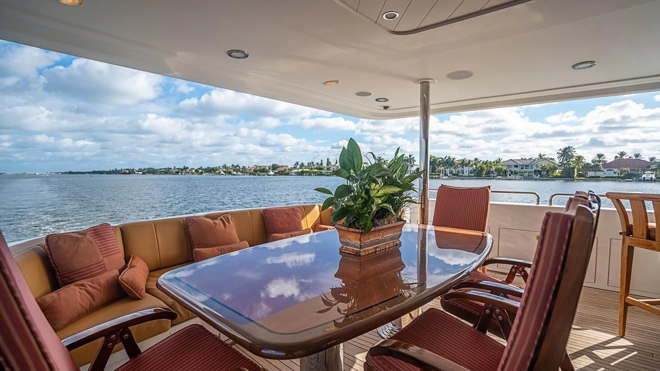 a table with chairs and a pool aboard KEMOSABE Yacht for Charter