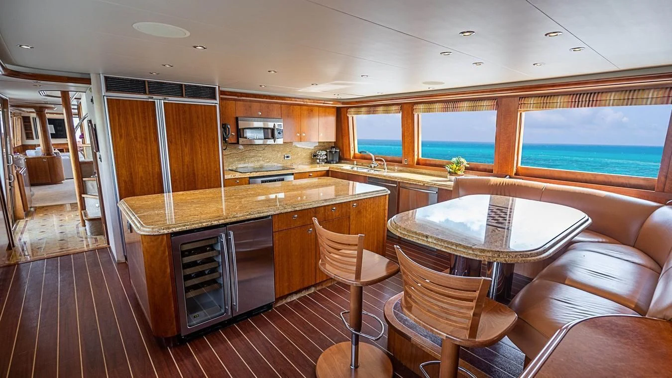 a kitchen with a table and chairs aboard KEMOSABE Yacht for Charter