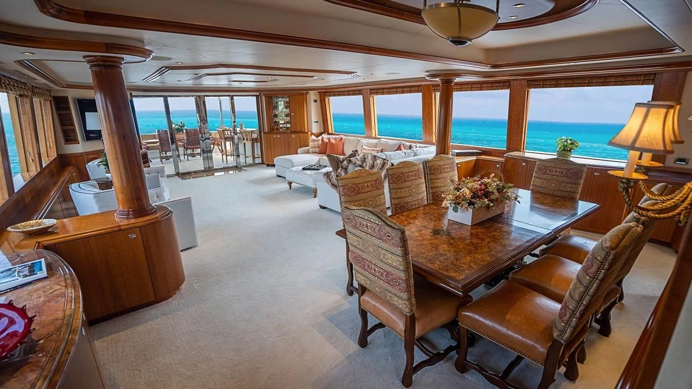 a large living room with a large table and chairs aboard KEMOSABE Yacht for Charter