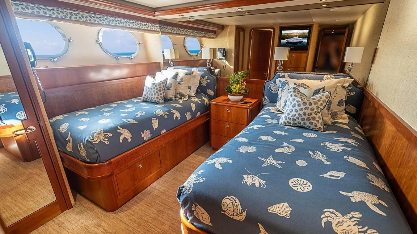 a bedroom with a bed and a dresser aboard KEMOSABE Yacht for Charter