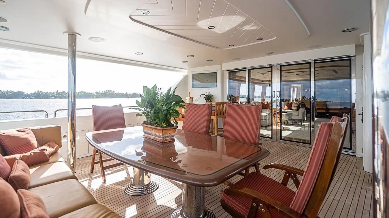 a room with a table chairs and plants aboard KEMOSABE Yacht for Charter