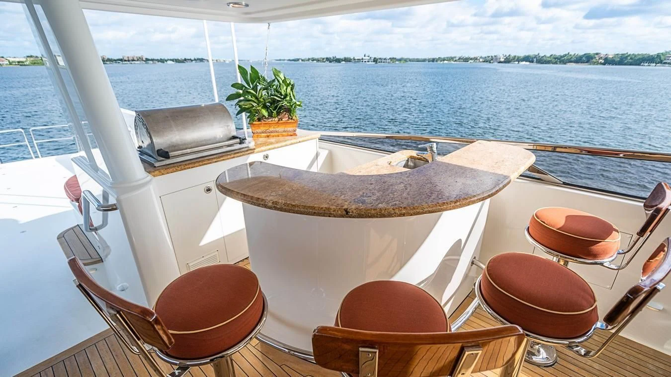 a table with chairs on it by the water aboard KEMOSABE Yacht for Charter