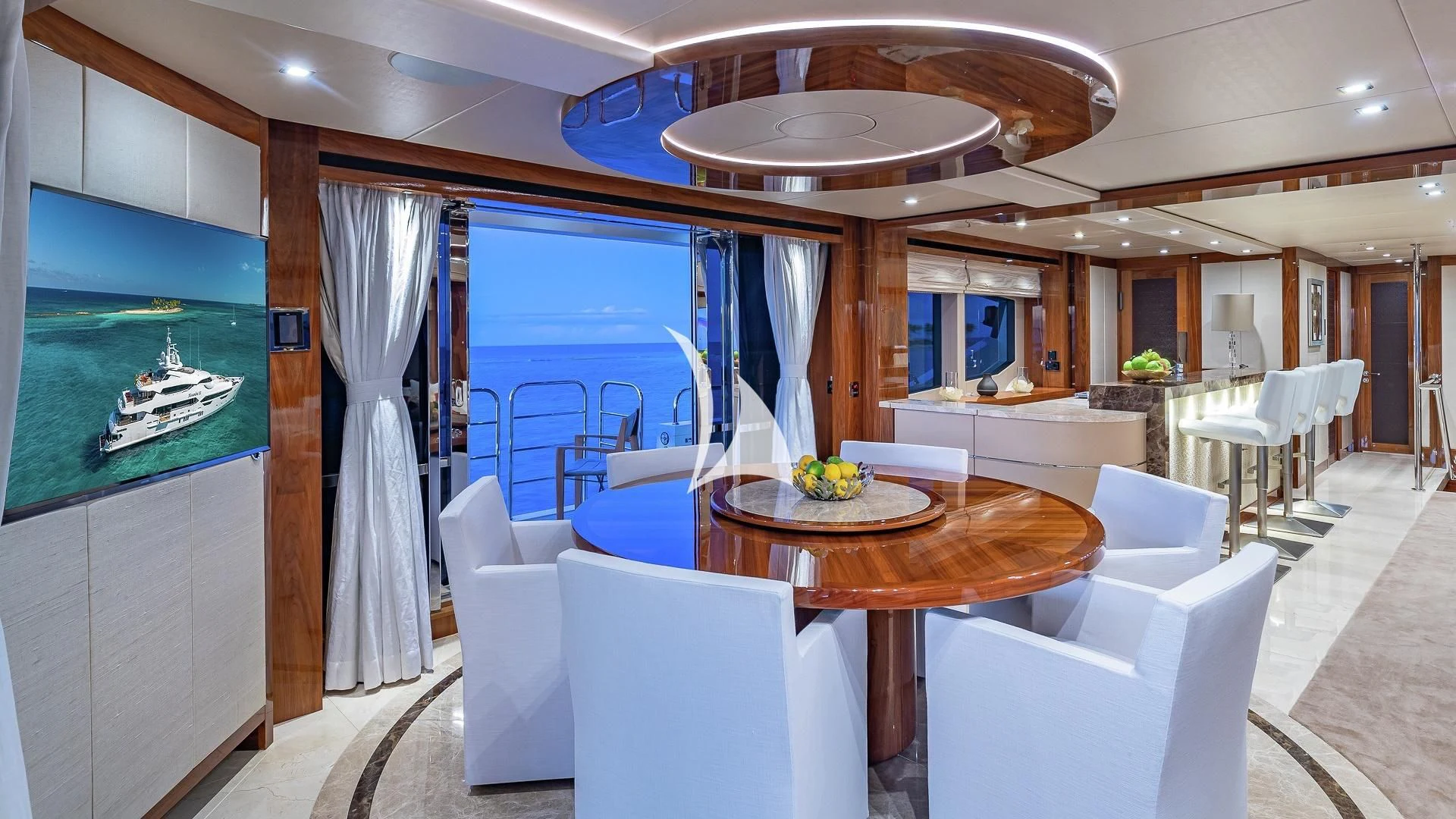 a room with a table chairs and a television aboard ALESSANDRA III Yacht for Charter