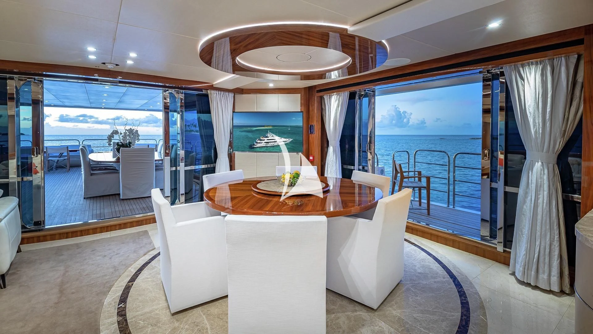 a room with a table chairs and a large window aboard ALESSANDRA III Yacht for Charter