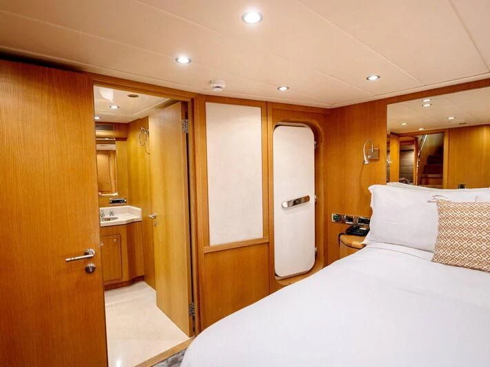 a bedroom with a bed and a closet aboard BANDIDO I Yacht for Sale