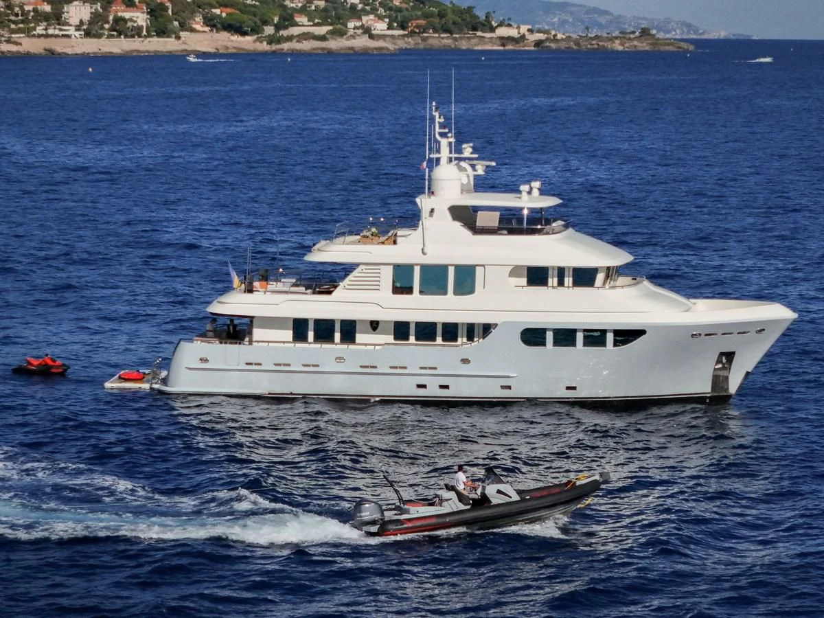 a large white boat with a couple of people on it aboard BANDIDO I Yacht for Sale
