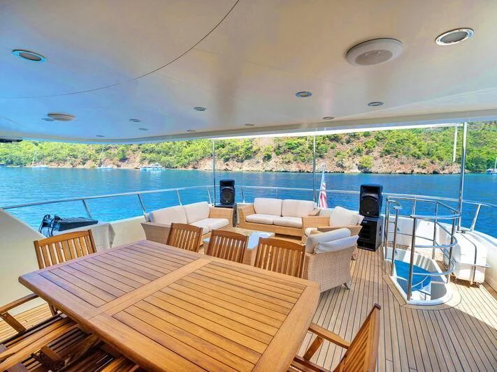 a deck with a table and chairs on it aboard BANDIDO I Yacht for Sale