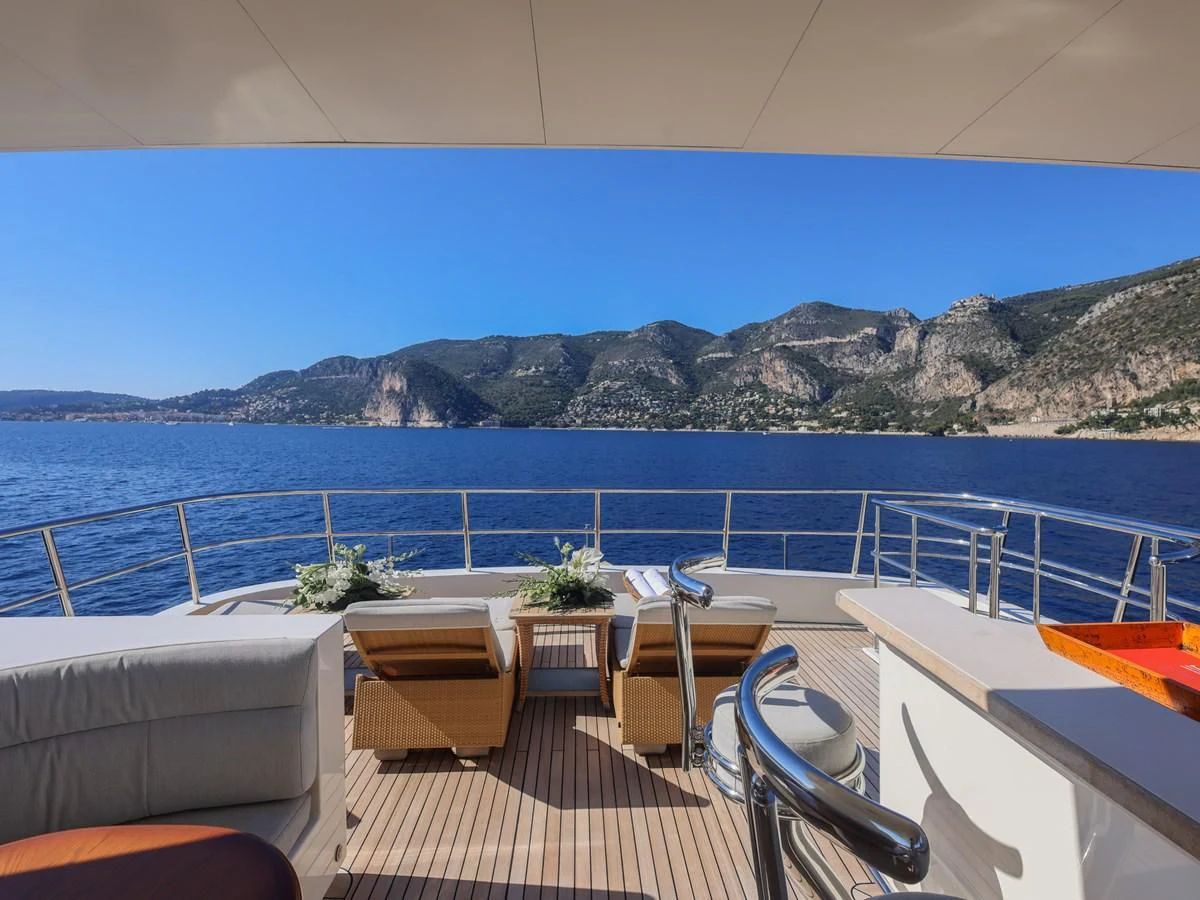 a deck with chairs and tables on it by the water aboard BANDIDO I Yacht for Sale