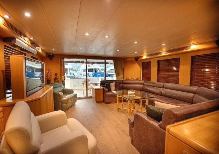 a living room with a tv and sofas aboard BANDIDO I Yacht for Sale