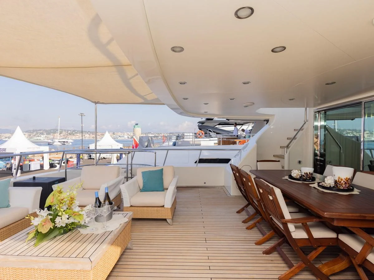 a room with a table chairs and a large boat in the background aboard BANDIDO I Yacht for Sale