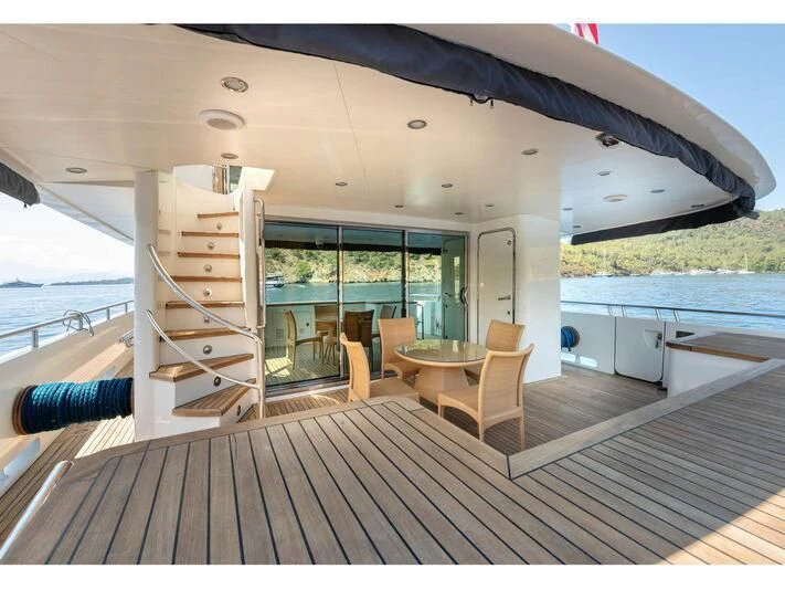 a deck with a table and chairs aboard BANDIDO I Yacht for Sale