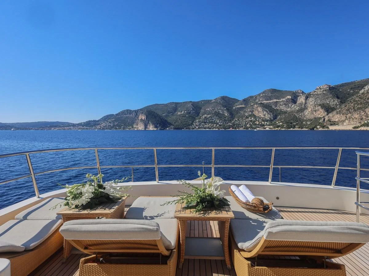 a deck with chairs and plants on it by the water aboard BANDIDO I Yacht for Sale