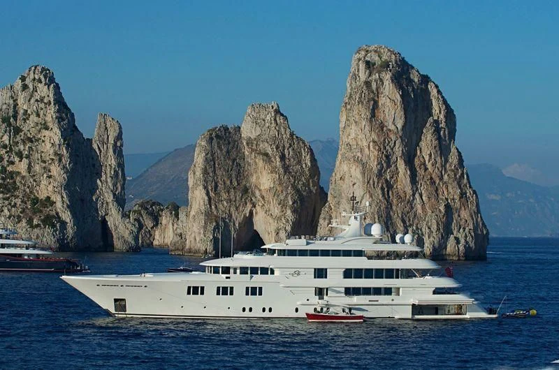 a boat in the water with Faraglioni in the background aboard FELIX Yacht for Sale