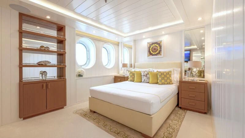 a bedroom with a bed and a mirror aboard FELIX Yacht for Sale