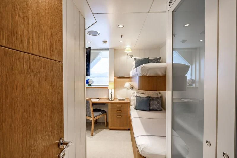a bedroom with a bed and a desk aboard FELIX Yacht for Sale