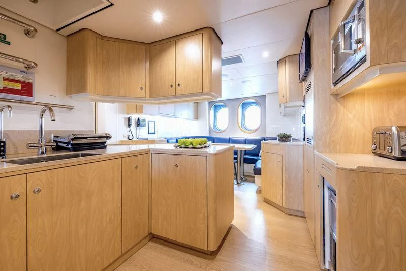 a kitchen with wooden cabinets aboard FELIX Yacht for Sale