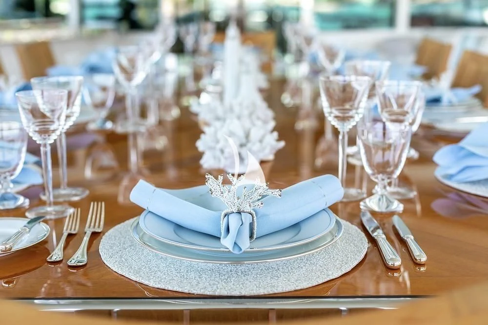 a white plate with silverware and a white bow on it aboard FELIX Yacht for Sale