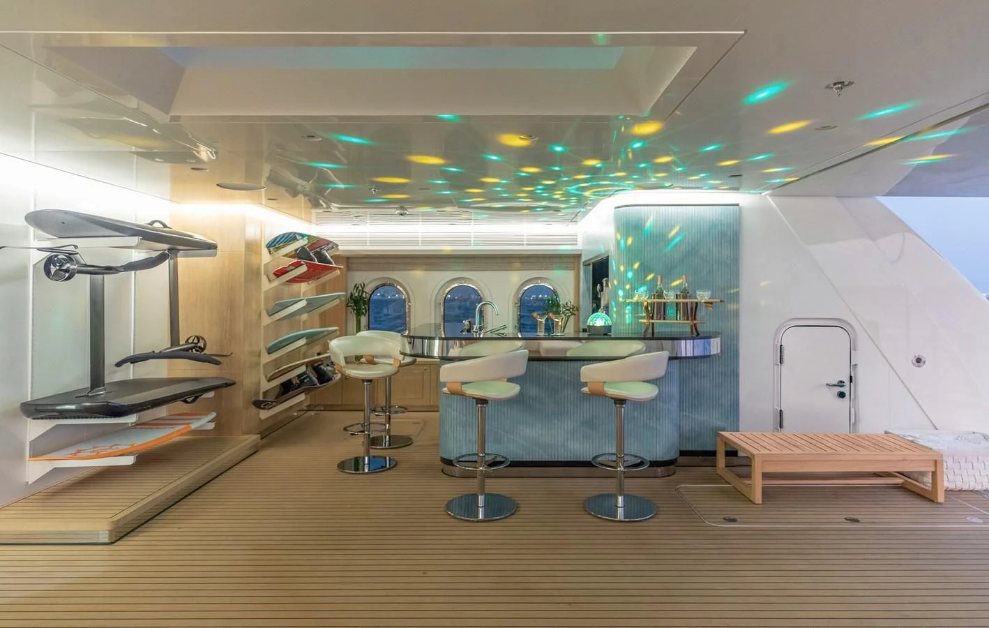 a room with stools and a shelf with books on it aboard FELIX Yacht for Sale