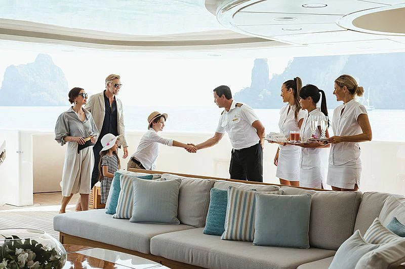 a group of people standing on a couch aboard FELIX Yacht for Sale