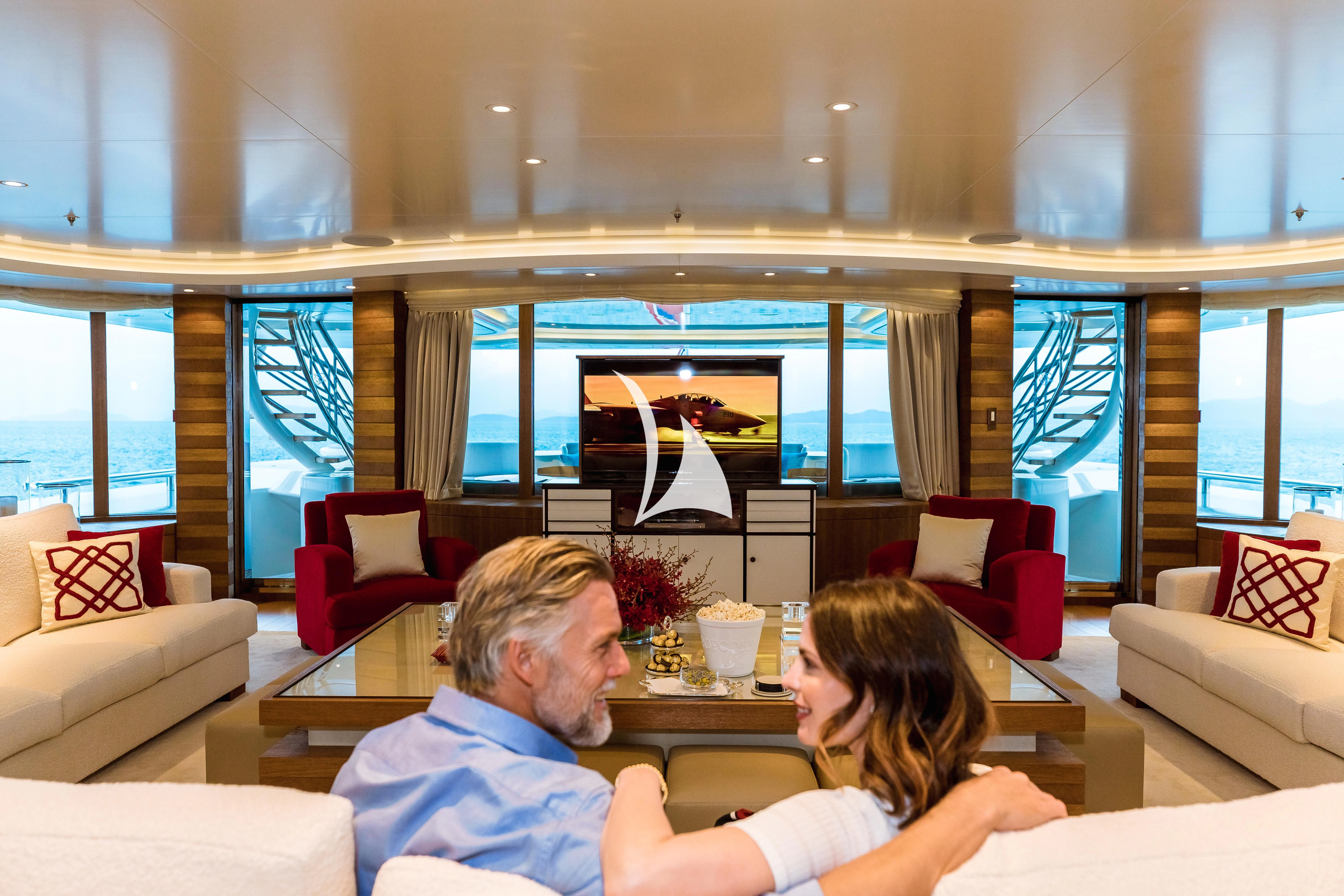 a couple sitting on a couch in a living room aboard FELIX Yacht for Sale
