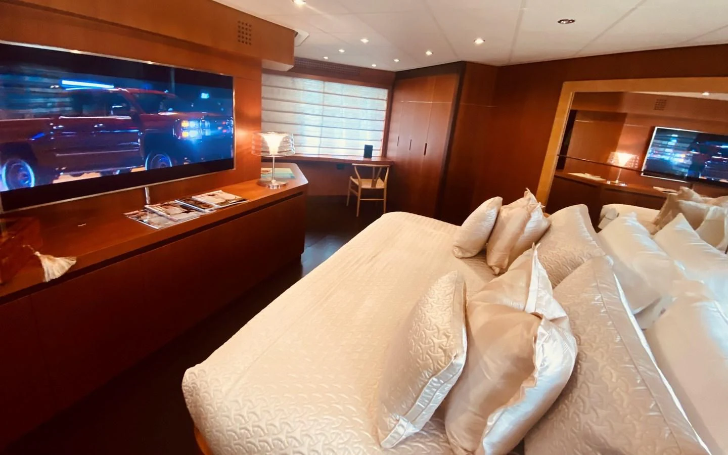a bed with a television in the background aboard ROMPEMAR Yacht for Sale
