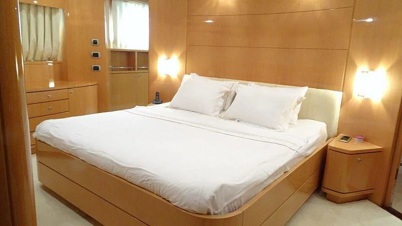 a bed with white sheets aboard SHERAN Yacht for Sale