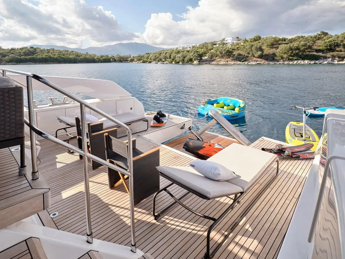 a deck with a boat and chairs on it by a body of water aboard ZILVAR IV Yacht for Sale