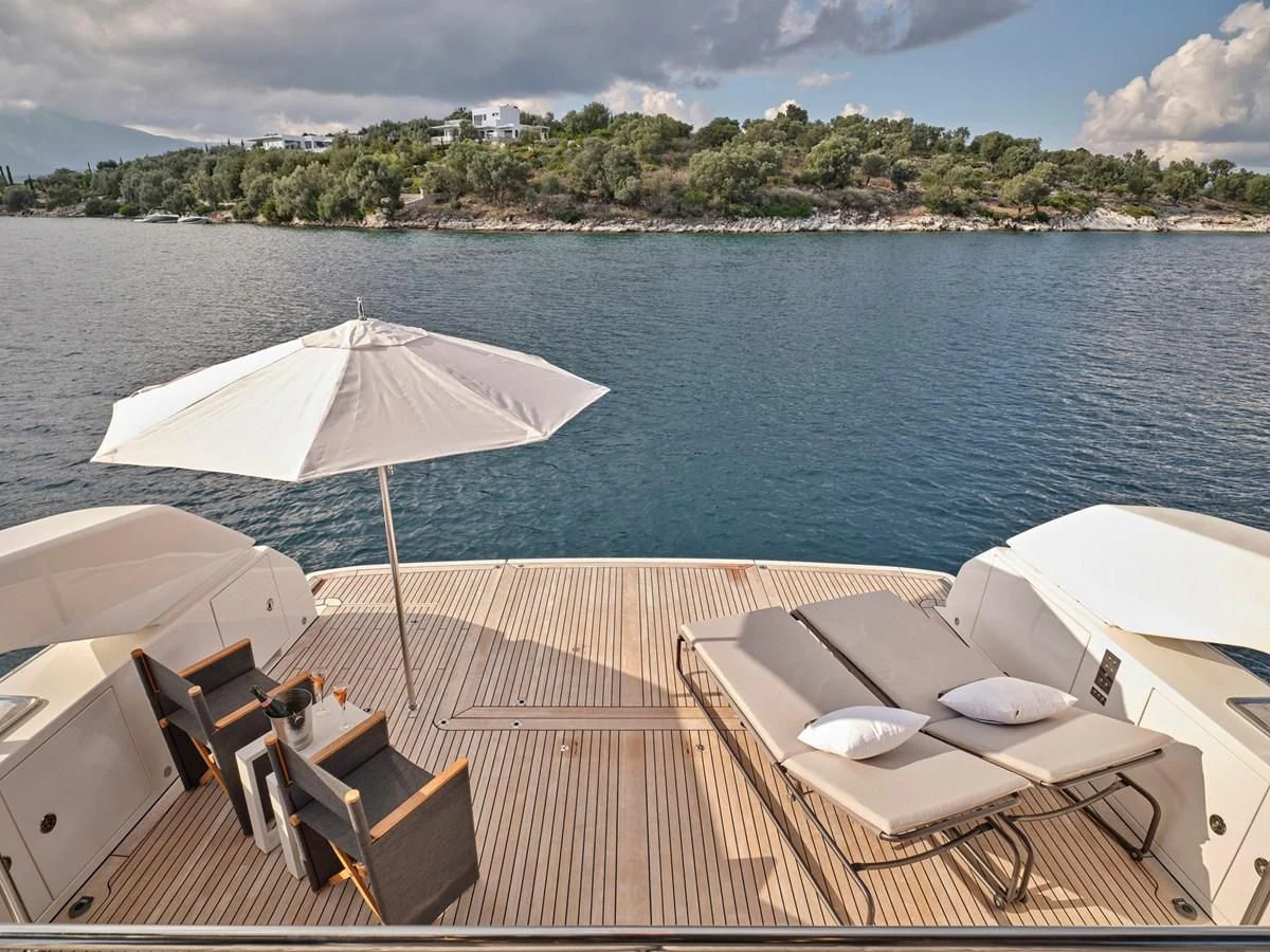 a group of tables and chairs on a deck with an umbrella aboard ZILVAR IV Yacht for Sale