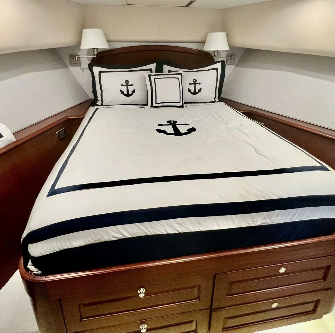 a bed with a blue and white striped pillow aboard LADY B Yacht for Sale