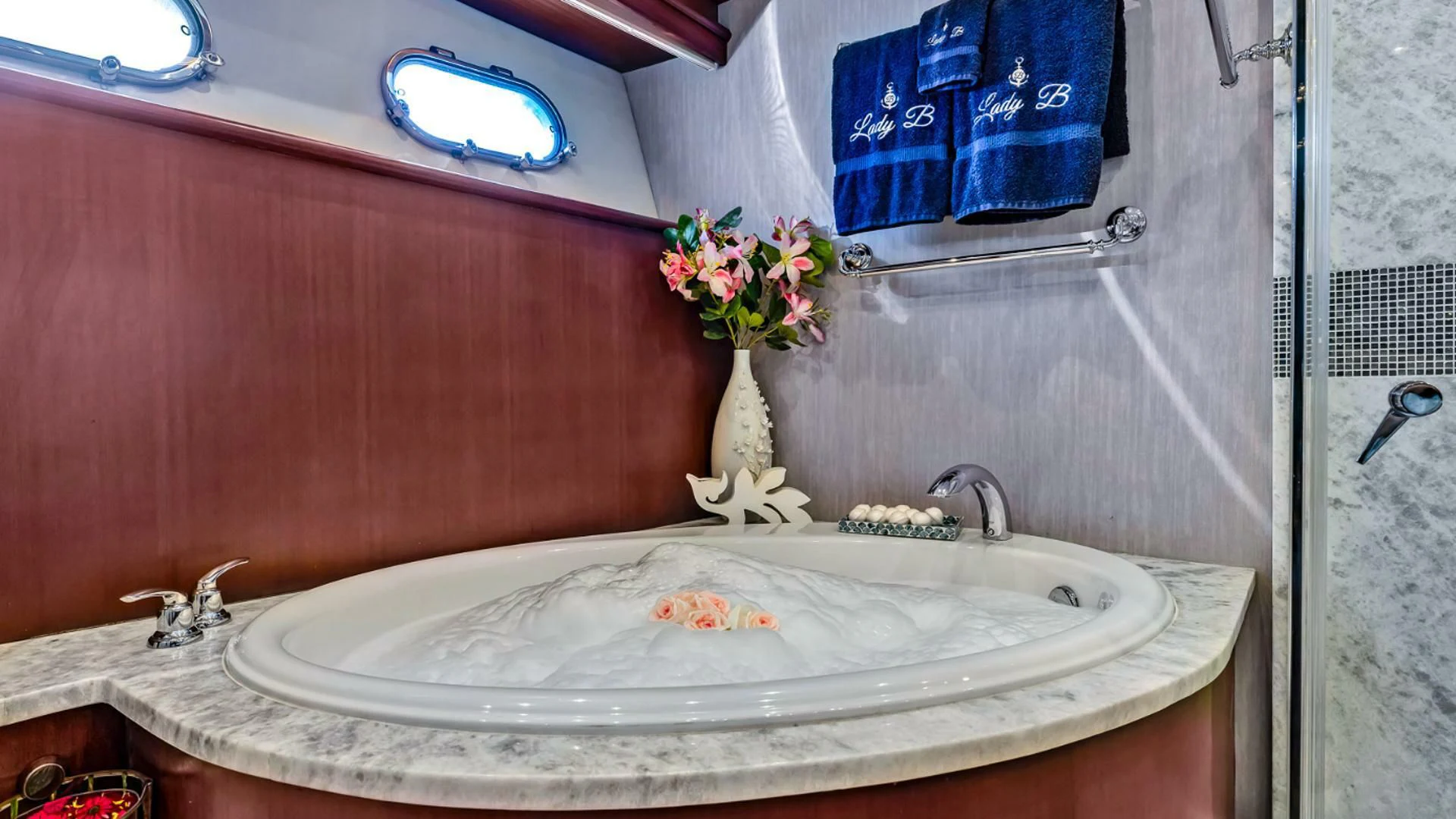 a bathroom sink with a vase of flowers on it aboard LADY B Yacht for Sale