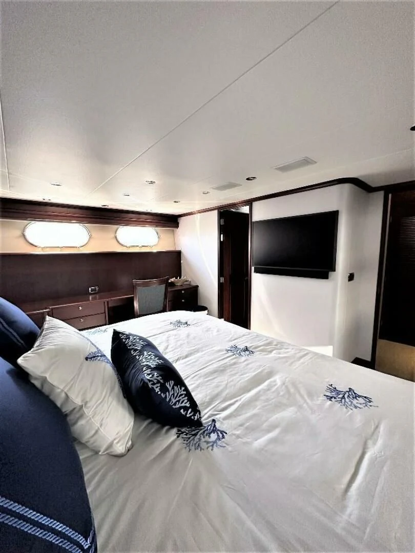 a bed with a white comforter and pillows aboard LADY B Yacht for Sale