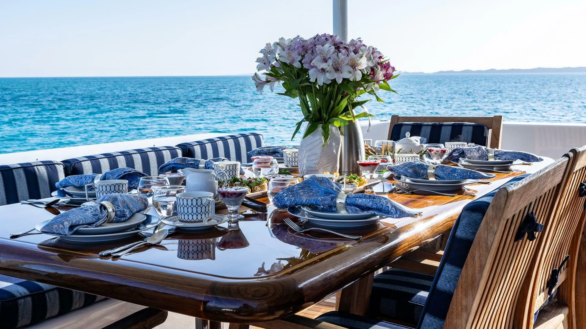 a table set with place settings and flowers on it aboard LADY B Yacht for Sale