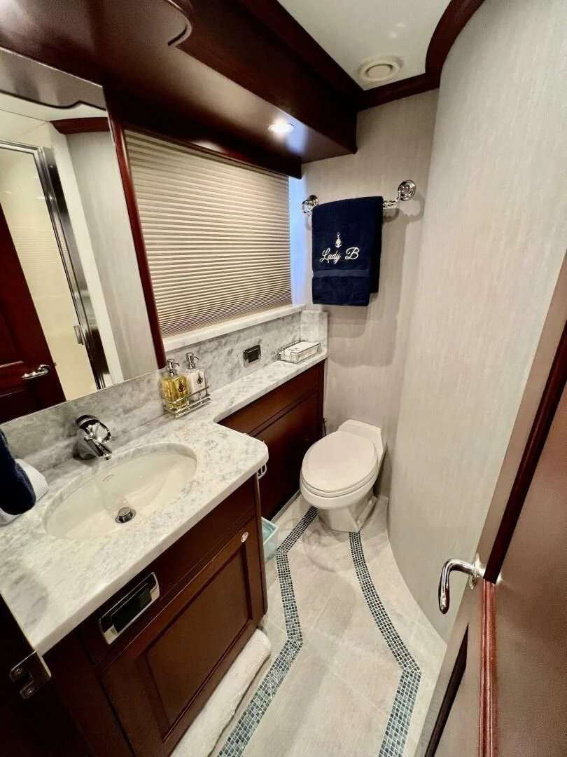 a bathroom with a sink toilet and a mirror aboard LADY B Yacht for Sale