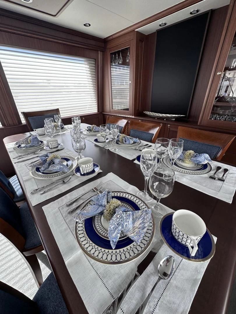 a table set with empty plates and silverware aboard LADY B Yacht for Sale