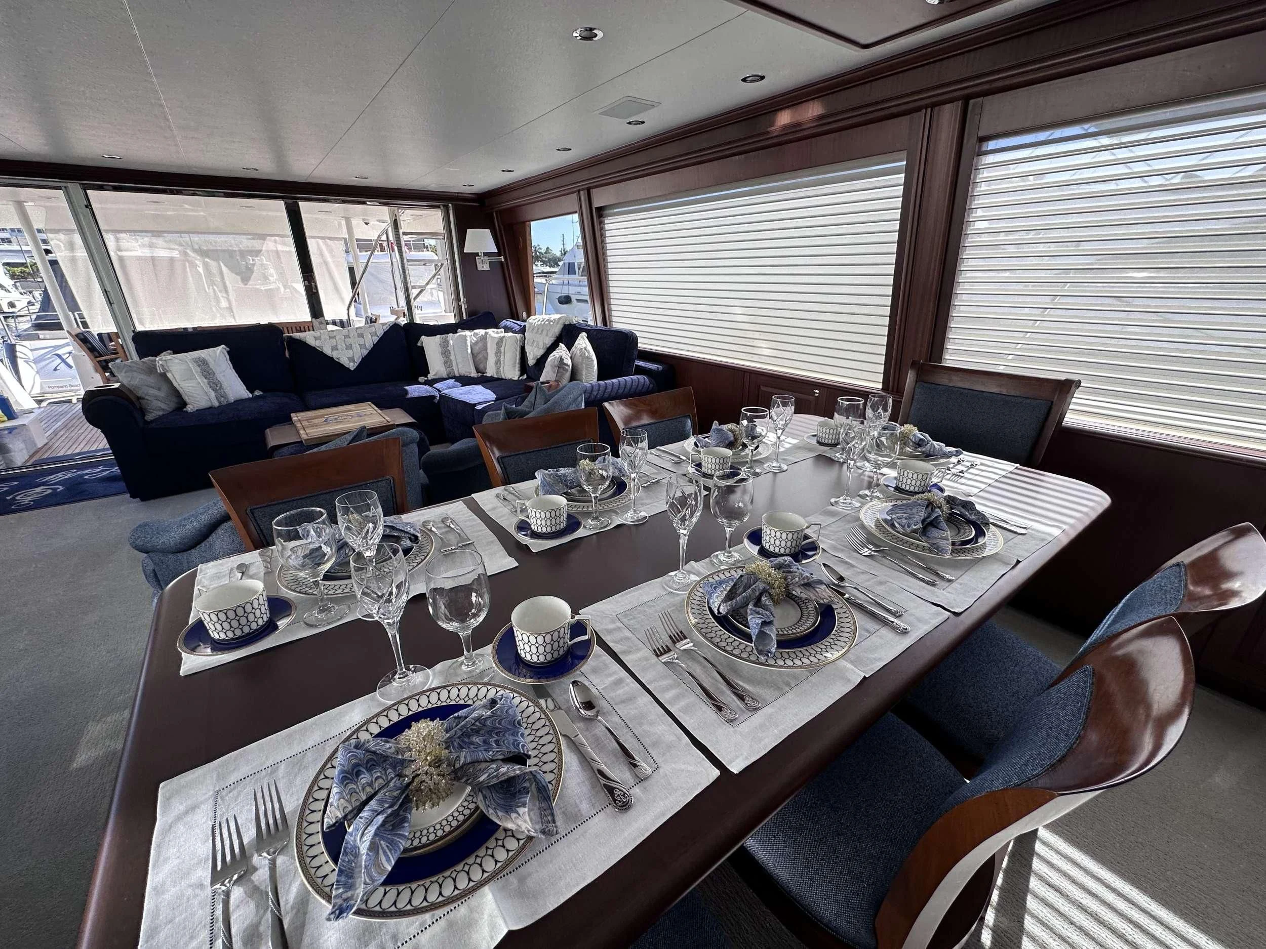 a dining table with plates and glasses aboard LADY B Yacht for Sale