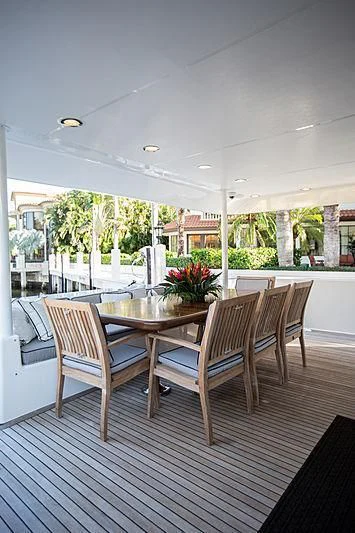 a deck with a table and chairs aboard LADY B Yacht for Sale