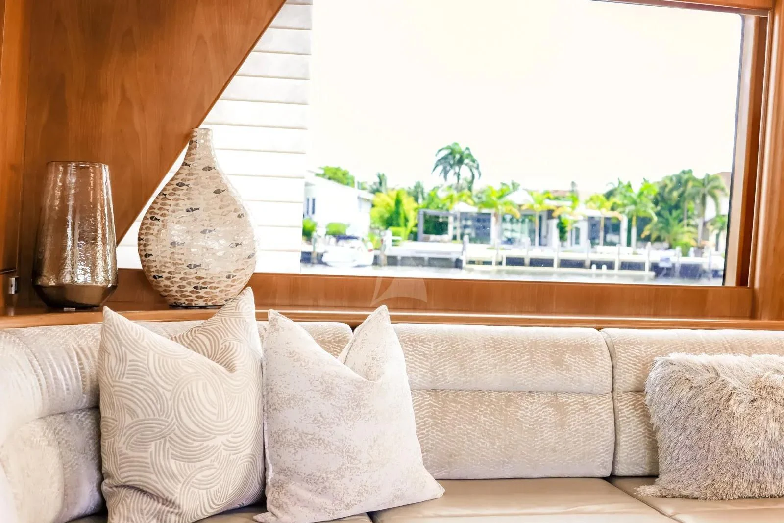 a couch and pillows in front of a window aboard ANDIAMO Yacht for Charter