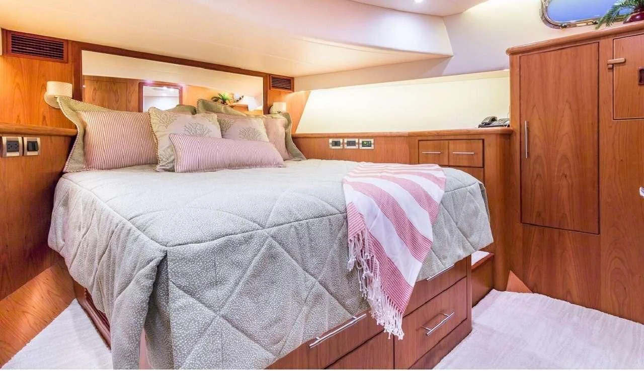 a bed with a purple comforter aboard ANDIAMO Yacht for Charter