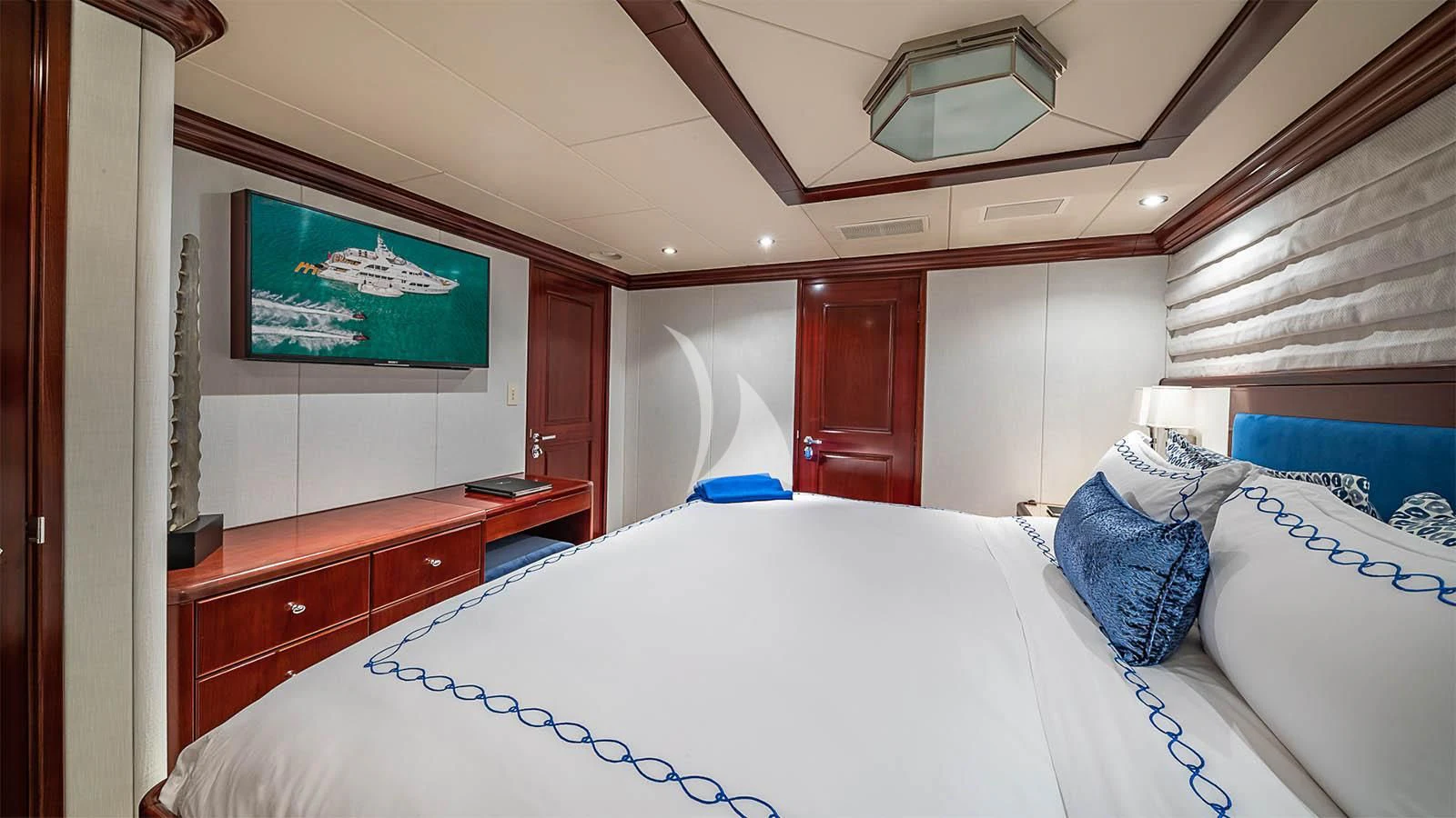 a bedroom with a bed and a television aboard CARTE BLANCHE Yacht for Charter