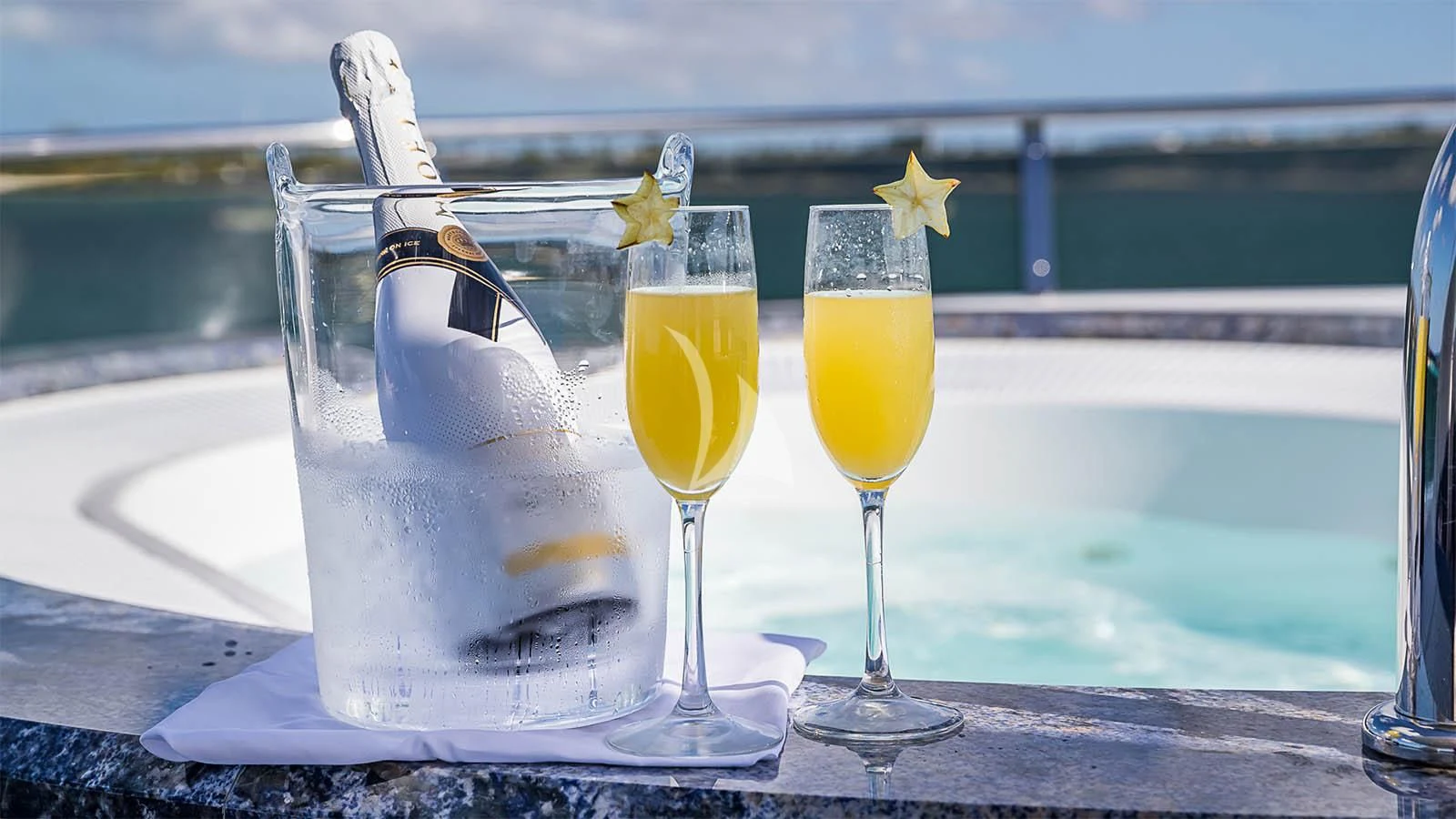 a champagne glass with a champagne bottle and glasses of champagne aboard CARTE BLANCHE Yacht for Charter