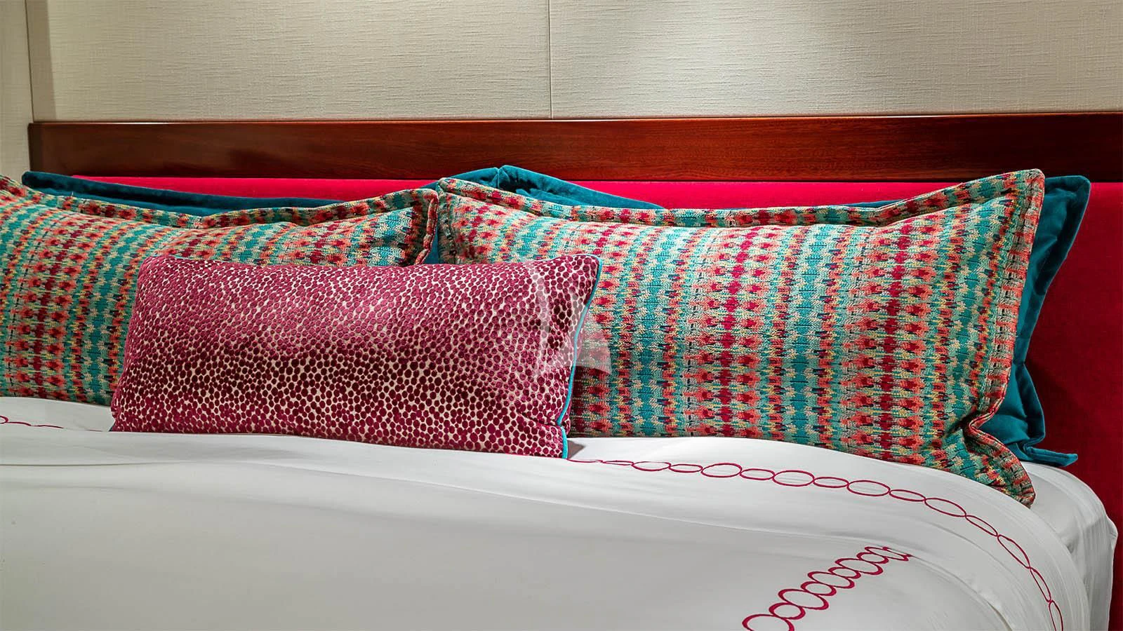 a colorful pillow on a bed aboard CARTE BLANCHE Yacht for Charter