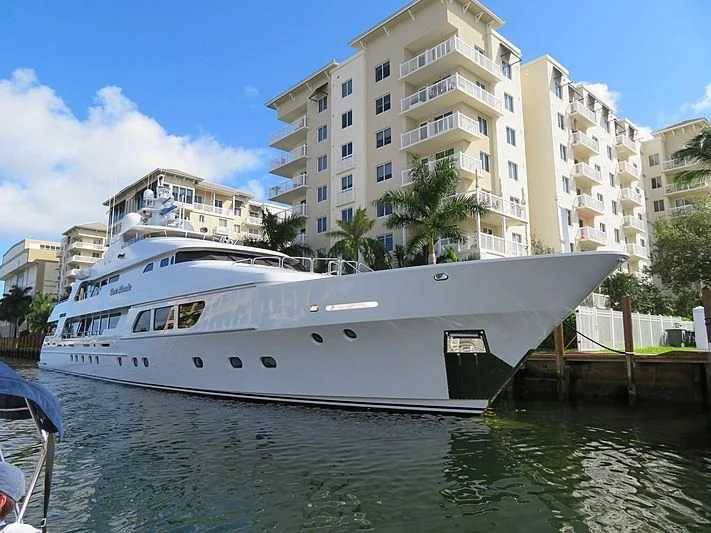 a white boat docked in a harbor aboard CARTE BLANCHE Yacht for Charter